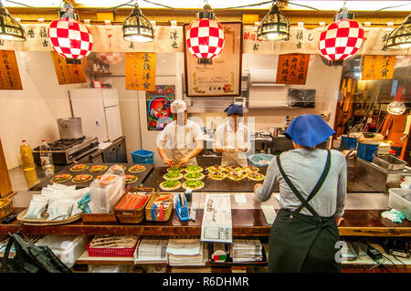 Chef cuisinier la préparation dans des assiettes chaudes Okonomiyaki dans Gion, Kyoto, Japon Banque D'Images