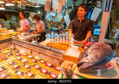 Un homme la préparation des marchandises dans les fruits de mer au marché Tsukiji Shop c'est un grand marché aux poissons de Tsukiji, District de Chuo Ward, Tokyo, Japon Banque D'Images