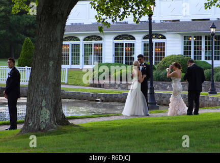 Westport, CT USA. Juin 2013. Les personnes âgées à la nuit de s'amuser et prendre des photos tout en jeune homme par l'arbre attend avec impatience sa date. Banque D'Images