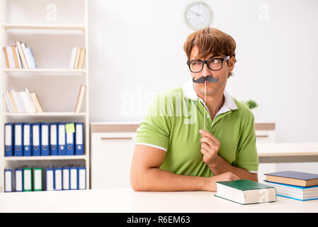 Étudiant avec fake moustache reading book Banque D'Images