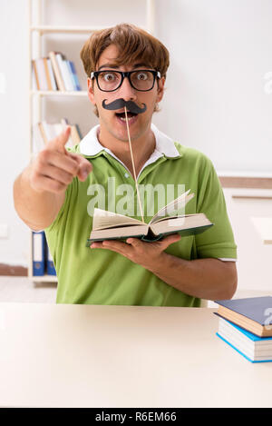 Étudiant avec fake moustache reading book Banque D'Images