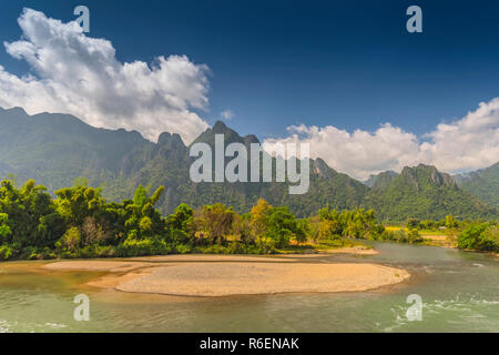 Champ de riz entouré par des formations rocheuses à Vang Vieng, Laos Vang Vieng est une destination populaire pour le tourisme d'aventure dans un paysage karstique calcaire Banque D'Images