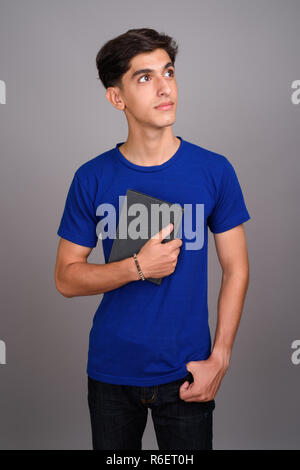 Beau jeune adolescent Persique student holding book Banque D'Images