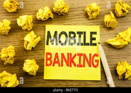 Parole, l'écriture Mobile Banking. Concept d'affaires pour les services bancaires par Internet e-bank écrit le post-it sur le fond en bois. Papiers pliés sur l'arrière-plan jaune Banque D'Images