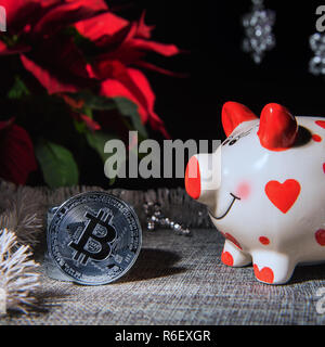 Image de carrés de couleur argent, monnaie bitcoin souvenir cochon blanc et rouge de l'argent banque et décor de Noël. Focus sélectif. L'étoile de Noël Retour à l'usine Banque D'Images