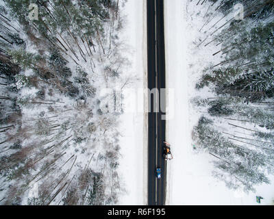 Forêt d'hiver et de la route d'asphalte. Vue de dessus. La photo a été prise avec un drone. Forêt de pins et d'épinettes noires avec une route dans la neige. Banque D'Images