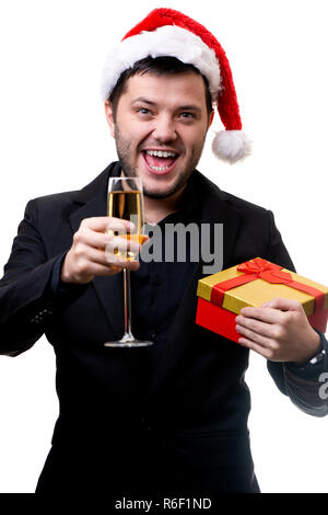 Photo d'un homme in Santa hat avec don et une coupe de champagne dans les mains Banque D'Images