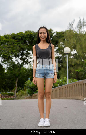 De toute la longueur belle Asian woman relaxing at the park Banque D'Images