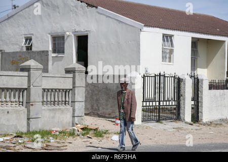 Cape Town Afrique du Sud 28 déc 2013 Un homme passe devant une maison à Guguletu une ville située à 15 km de Cape Town, Afrique du Sud. Banque D'Images