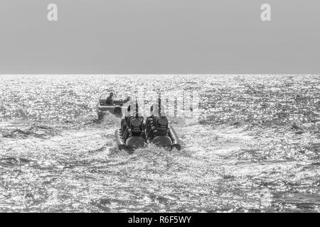 Les vacanciers heureux touristes ride une banane gonflable dans la mer, photo en noir et blanc Banque D'Images