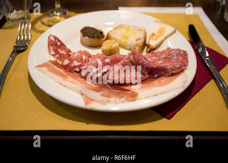 Vue horizontale d'un assortiment de charcuterie, de pain et de fromage sur une assiette en Italie. Banque D'Images