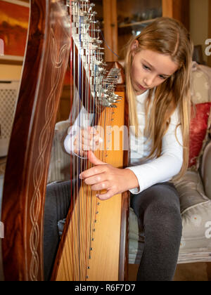 Portrait vertical d'une jeune fille jouant de la harpe. Banque D'Images