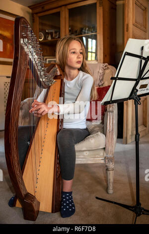 Portrait vertical d'une jeune fille la pratique d'une harpe. Banque D'Images