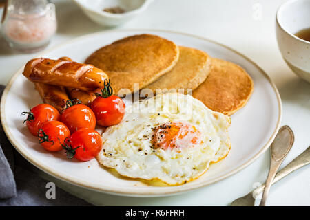 L'avoine banane crêpes avec saucisses, œufs frits et tomates cerises Banque D'Images