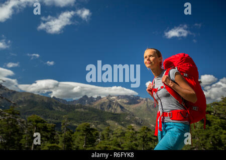 Jolie, female hiker en haute montagne avec son sac à dos géant, se préparer pour une randonnée Banque D'Images