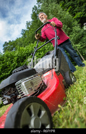 Man tondre la pelouse de son jardin Banque D'Images