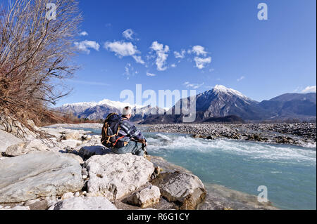 Randonneur assis sur la rive de la rivière, à la montagne paysage. Banque D'Images