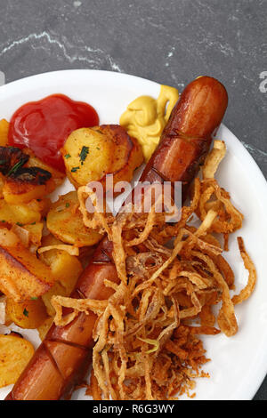 Close up partie des pommes de terre rôties avec saucisse Banque D'Images