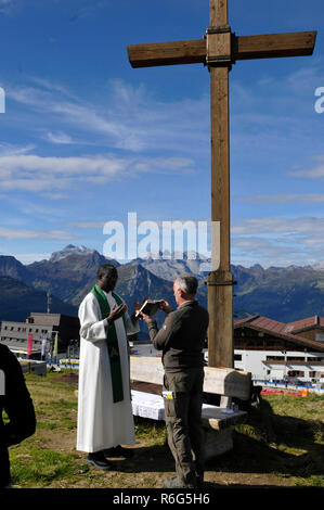 Cérémonie religieuse sur la montagne au-dessus de la ville de Schruns Hochfirst dans la vallée de Montafon avec un prêtre de l'Ouganda Banque D'Images