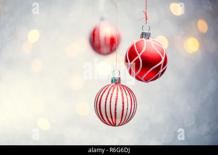 Photo de Noël trois boules rouges sur fond gris avec des taches. Banque D'Images