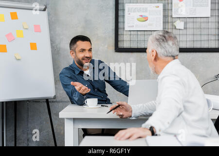 Deux beaux businessmen talking and gesturing in office Banque D'Images