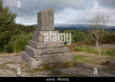 Un mémorial commémorant l'ouverture de la Betws-Y-Coed Waterworks surplombe Llyn, un réservoir d'eau douce l'ELSI en Galles. Banque D'Images