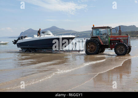 Un tracteur est utilisé pour récupérer et de lancer de petites embarcations sur la péninsule de Llyn au Pays de Galles Banque D'Images