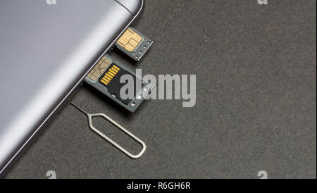 Téléphone mobile et d'emplacements ouverts pour nano cartes SIM, lecteur micro SD et clé de métal sur fond gris avec copie espace Banque D'Images