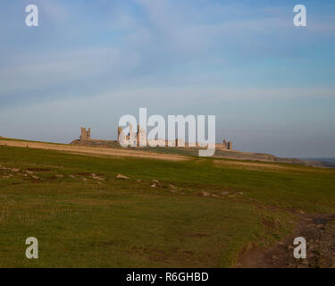 Château de Dunstanburgh sur la côte de Northumberland, vu depuis le village de Craster Banque D'Images