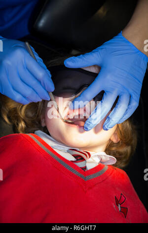 Jeune fille 4 an / enfant de quatre ans portant des lunettes de soleil de protection lors de l'enregistrement jusqu'à la chirurgie du NHS / cabinet dentaire. Royaume-uni (104) Banque D'Images