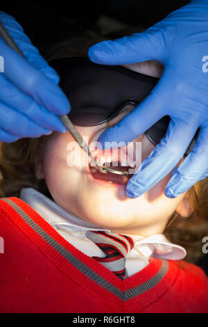 Jeune fille 4 an / enfant de quatre ans portant des lunettes de soleil de protection lors de l'enregistrement jusqu'à la chirurgie du NHS / cabinet dentaire. Royaume-uni (104) Banque D'Images