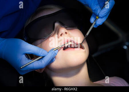 Jeune fille 8 an / 8 ans la protection de l'enfant portant des lunettes de soleil lors de l'enregistrement jusqu'à la chirurgie du NHS / cabinet dentaire. Royaume-uni (104) Banque D'Images