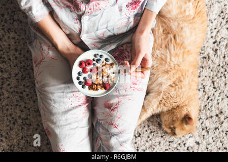 Girl eating healthy breakfast bowl avec yogourt et petits fruits. Régime Végétarien, petit-déj. Vue d'en haut Banque D'Images