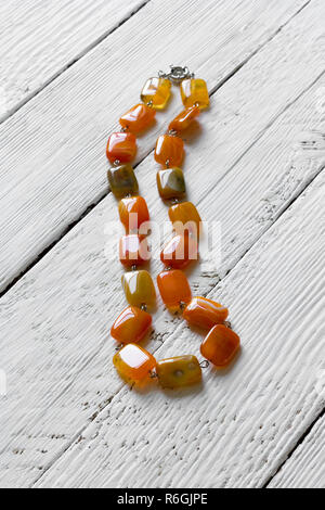 Perles de pierre semi-naturelles agate sur table en bois blanc Banque D'Images