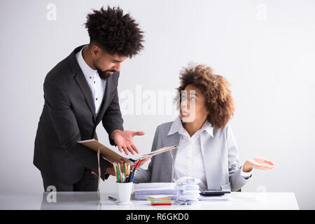 Businessman Showing Erreur de sa collègue féminine Banque D'Images