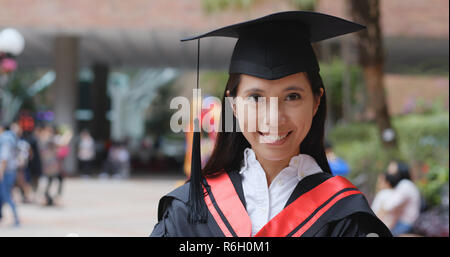Woman wearing graduation gown Banque D'Images