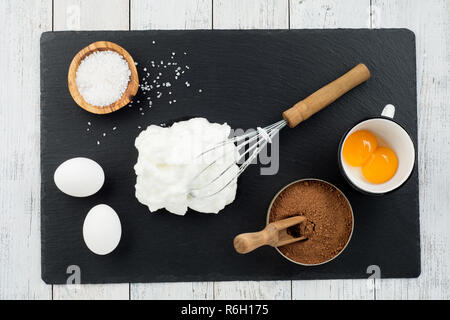 Concept de boulangerie, ingrédients pour faire du gâteau au chocolat sur fond de bois blanc,vue d'en haut Banque D'Images