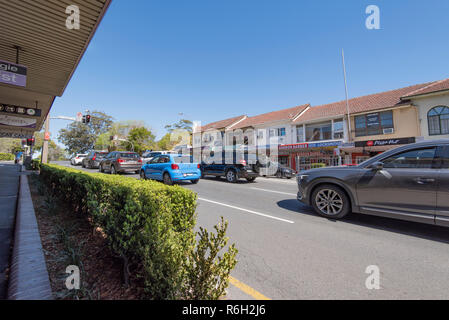 En regardant vers le sud, la ligne des magasins la Pacific Highway à Gordon sur la rive nord de Sydney en Australie que le trafic attend à un feu rouge, un samedi matin. Banque D'Images