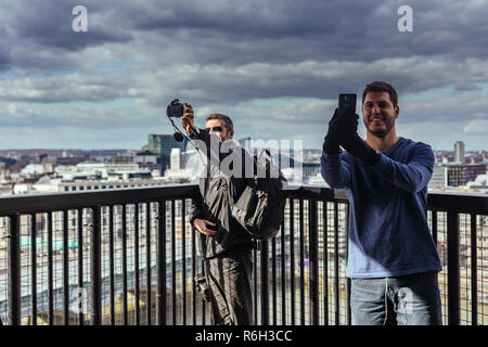 Londres/UK - 25 mars 2018 : deux hommes en tenant vos autoportraits contre Londres cityscape Banque D'Images