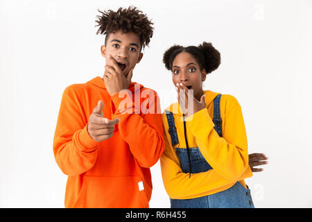 Image de l'heureux couple dans des vêtements colorés au doigt vous avez isolé sur fond blanc Banque D'Images