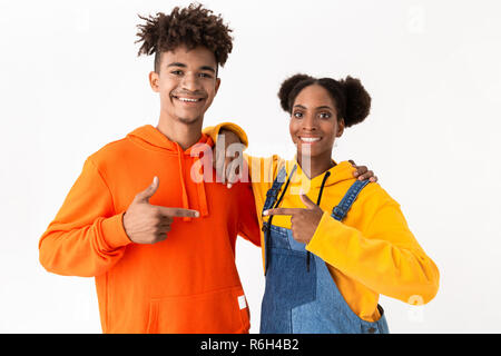 Image de l'african american garçon et une fille dans des vêtements colorés doigt à chaque autre isolated over white background Banque D'Images