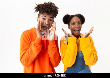 Image de l'heureux couple dans des vêtements colorés en criant et gesticulant isolé sur fond blanc Banque D'Images