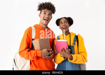 Photo de joyeux étudiants noirs américains portant des sacs à dos holding exercise books isolé sur fond blanc Banque D'Images
