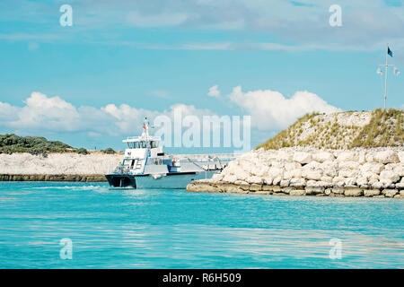 Great Stirrup Cay, Bahamas - 8 janvier 2016 : navire de croisière ou de plaisance dans la baie de la mer ou l'océan laissant avec rocky coast sur journée ensoleillée sur ciel bleu. Transport de l'eau. Vacances d'été. Voyager Banque D'Images