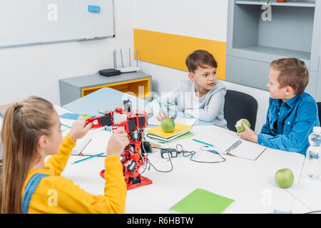 Programmation et écoliers robot manger des pommes au cours de la classe d'enseignement de la tige Banque D'Images