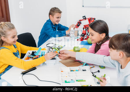 Enfants souriants qui travaillent ensemble sur la tige en projet classrom Banque D'Images