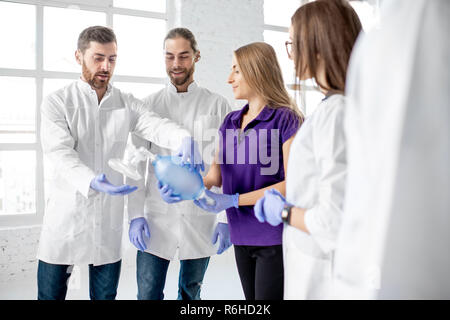 Groupe de medecins se tenant ensemble avec la respiration outil au cours de la formation aux premiers secours à l'intérieur Banque D'Images