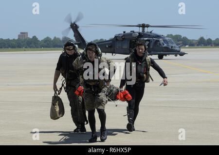 De gauche, le s.. Robert Hall, le s.. Travis Lester, et les cadres supérieurs d'un membre de la Juge, Eddie 38e Escadron de sauvetage pararescuemen attribué à Moody Air Force Base, Ga., effectuer un aviateur avec blessures simulées vers un escadron de transport aérien 3d C-17 Globemaster III, 17 mai 2017, au cours de l'effort de sauvetage rapide à Langley AFB, en Virginie le C-17 a été préparé et prêt à décoller pour un vol d'évacuation aéromédicale simulé lorsque l'équipe de recherche et de sauvetage est arrivé. Banque D'Images