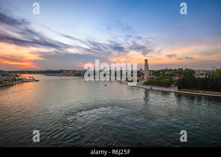 Le monument du marin italien, la promenade et la baie au coucher du soleil et s'allume dans la ville portuaire de Brindisi, Italie, dans la région du sud des Pouilles Banque D'Images