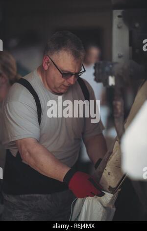 Le lieutenant-colonel Ken Kieliszek, un spécialiste des services de santé affecté à la 107e Escadre attaque, Station de la Réserve aérienne de Niagara Falls, New York Air National Guard, remplit des sacs en réponse à l'état d'urgence Gov. Andrew Cuomo a déclaré le 2 mai pour l'inondation le long du lac Ontario, au ministère des Travaux publics Kendall, Kendall, N.Y., 18 mai 2017. Les membres de la Garde Nationale de New York sont en mesure de remplir autour de 5 000 sacs par jour de Kendall, qui sont ensuite prises pour les zones vulnérables autour de la rive du lac Ontario, y compris les foyers et les entreprises. Banque D'Images